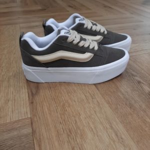 Vans Knu Stack Le volume XXL des années 90 avec une semelle plateforme épaisse Les Vans Knu Stack revisitent d'abord avec modernité un classique des années 90, puis montent d'un cran. Pour commencer, avec leur semelle plateforme, elle sont deux fois plus hautes. Puis, elles sont dotées d'une languette rembourrée et d'une bande latérale Sidestripe™ en 3D. Enfin, ces chaussures spectaculaires réinterprètent un véritable classique avec des tendances actuelles et des finitions saisissantes. La marque C’est en 1966 que Paul, accompagné de son frère Jim et de ses amis Gordy et Serge, ouvre les portes de la Van Doren Rubber Company au 704 East Broadway à Anaheim, en Californie. Leur façon de travailler est alors unique, vendant leurs chaussures d’où elles sont fabriquées. « Des baskets en toile pour toute la famille » tel était le slogan qu’affichaient les boîtes à chaussures à l’époque. C’est le principe novateur de la Van Doren Rubber Company, fondée par ces deux frères originaires de Boston : produire à la commande et sur place, dans la petite usine qui jouxte les 40 m2 du magasin. Et vendre en direct cette chaussure en toile robuste reposant sur une semelle gaufrée en caoutchouc vulcanisé et antidérapante. Hélas, cette sneaker disparaît brutalement des radars avec la faillite de Vans en 1983. Mais l’histoire de Vans n’écrivait pas son point final. Elle mettra vingt ans à redevenir le signe extérieur d’appartenance à la religion du cool, aux pieds des rockers, des grands ados et des stars d'Hollywood (Justin Bieber, Zac Efron, Harry Styles…). À bientôt 60 ans, cet indéboulonnable totem de la culture skate est aujourd’hui un classique du dressing estival porté flambant neuf à un mariage ou en fin de vie à la plage. Avant de les renouveler les yeux fermés…