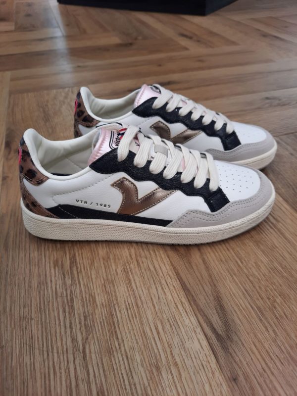 Smash Animal Pop Style vintage et confort sont les caractéristiques des baskets Smash Animal Pop de la collection femme 1985. Fabriquées en cuir souple de haute qualité, détails en PU et imprimé animalier à l'arrière. Détails gaufrés dorés sur le côté, logo métallique et étiquette en caoutchouc gaufrée à l'arrière. Doublure en microfibre respirante et semelle 100 % caoutchouc à la finition antique et à la texture rugueuse. Comprend une semelle intérieure ergonomique qui s'adapte à la forme du pied et procure une sensation de confort. La marque Victoria est une marque qui a vu le jour en 1915 en Espagne. Le fondateur de la marque a commencé l'aventure avec une petite tennis qu'il a nommée comme sa femme adorée. Les chaussures Victoria ont évolué avec le temps bien sûr mais la marque s'évertue à conserver son ADN. Les Victoria évoluent et se parent de nouvelles couleurs, de matières originales ou d'imprimés, mais la base de la chaussure reste la même pour le plus grand plaisir des fans de la première heure. Les designers proposent de vastes collections chaque année qui renouvelle l'essence de Victoria ce qui lui permet de rester parmi les marques favorites des Espagnoles.