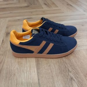 Gola Equipe Navy-chaussures pour homme gola equipe navy ginger dark sun -Gola la marque de Baskets Anglaise qui cartonne auprès de toutes les générations Aujourd’hui, Gola est une marque de chaussure à la fois tendance et streetwear. La marque Gola bénéficie aussi d'une bonne notoriété auprès des célébrités. Les stars anglaises comme les frères Gallagher, Robbie Williams ou encore Jude Law mettent en avant la marque Gola. La collection Gola allie les distinctions sportives de son riche héritage à des références modernes. C'est clairement une marque indémodable qui a su traverser les années. Appréciée de toute une génération, les chaussures Gola sont confortables et pleines de style. La marque est également très appréciée auprès des enfants et juniors. Plus de 100 ans après sa création, Gola possède la renommée qu’on lui connaît. En 2019, la marque lance une collection 100 % vegan, certifiée par le label Vegan Society