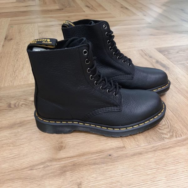 1460 Pascal Ambassador Nous avons repensé nos boots Dr. Martens 1460 Pascal Ambassador  plus souple au fini texturé. Ce modèle à 8 œillets est né le 1er avril 1960 et ultra-confortable à porter grâce à son cuir ultra-souple, durable et légèrement huilé qui s'embellit au fil du temps. Il présente aussi nos surpiqûres jaunes classiques et notre boucle d'enfilage jaune et noire au talon. Notre semelle à coussin d'air réputée vous permet de porter ces boots des heures durant en tout confort.  Dr. Martens s'attache aux personnes qui ont leur propre style mais qui partagent un même esprit, des personnes authentiques qui représentent quelque chose de concret. Qui aiment s'exprimer honnêtement. Qui sont différentes. Sur un plan stylistique, les silhouettes épurées de Dr. Martens permettent à celles et ceux qui les portent de les intégrer à leur style individuel et unique. Sur un plan pratique, la solidité et le confort réputés de nos chaussures les rendent parfaites pour un quotidien partagé entre concert et mode urbaine. Et finalement, sur un plan émotionnel, elles sont une marque d'attitude et de confiance en soi. Mais ça n'a pas toujours été le cas. À l'origine, Dr. Martens proposait des boots de travail simples qui ont même brièvement été vendues comme des chaussures de jardinage. Donc comment est-ce que ces boots utilitaires sont devenues l'une des icônes culturelles les plus importantes de notre époque moderne ? C'est une histoire unique et intéressante...