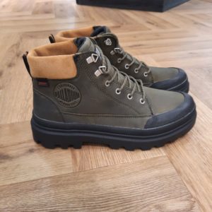 Pallatrooper Cuff Olive Les PALLATROOPER CUFF OLIVE WP+ sont une véritable merveille en termes d’esthétique et de fonctionnalité. En plus du look fantastique assuré par leur logo embossé et leur design élégant, ces bottes offrent un confort et un soutien exceptionnels. Imaginons que vous soyez dehors et qu’il se mette soudain à pleuvoir. Pas d’inquiétude : ces bottes sont imperméables et garderont donc vos pieds parfaitement au sec et à l’aise. Par ailleurs, leur semelle extérieure en caoutchouc assure l’adhérence sur toutes les surfaces. Et cerise sur le gâteau, la première de propreté amovible en EVA offre un amorti et un soutien tout au long de la journée. Une fois que vous aurez essayé ces bottes, vous vous demanderez comment vous avez pu vous en passer ! Palladium est une marque française qui propose depuis quelques décennies des chaussures en toile et en caoutchouc résistantes et durables. Avec des origines militaires et une forme bien reconnaissable, les Palladium traversent les générations sans prendre une ride (ou presque). Palladium est une marque française créée en 1920. À l'origine, son activité est bien différente de celle que l'on connait aujourd'hui : Palladium fabriquait des pneus pour l'aviation. La société fournissait alors la plupart des flottes aériennes européennes grâce à un procédé industriel unique : la vulcanisation du caoutchouc et de la toile. Au lendemain de la Seconde Guerre Mondiale, Palladium cesse peu à peu cette activité. En 1947, la société ouvre une usine à Pont de Cheruy, dans l'Isère, où elle commence à produire des chaussures selon le même principe de vulcanisation. Chaussures qui se révéleront tout aussi solides ! Le modèle emblématique de la marque est le "Pampa" qui équipe notamment la légion étrangère française.