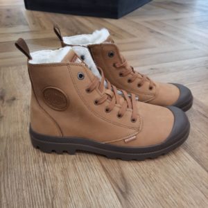 Pampa Hi Zip Camel Une version en nubuck souple de l’emblématique Pampa Hi Zip Camel. Une doublure chaude pour offrir à vos pieds un maximum de confort en ville. Nous avons ajouté des zips sur le quartier interne pour l’enfiler et la retirer facilement. Palladium est une marque française qui propose depuis quelques décennies des chaussures en toile et en caoutchouc résistantes et durables. Avec des origines militaires et une forme bien reconnaissable, les Palladium traversent les générations sans prendre une ride (ou presque). Palladium est une marque française créée en 1920. À l'origine, son activité est bien différente de celle que l'on connait aujourd'hui : Palladium fabriquait des pneus pour l'aviation. La société fournissait alors la plupart des flottes aériennes européennes grâce à un procédé industriel unique : la vulcanisation du caoutchouc et de la toile. Au lendemain de la Seconde Guerre Mondiale, Palladium cesse peu à peu cette activité. En 1947, la société ouvre une usine à Pont de Cheruy, dans l'Isère, où elle commence à produire des chaussures selon le même principe de vulcanisation. Chaussures qui se révéleront tout aussi solides ! Le modèle emblématique de la marque est le "Pampa" qui équipe notamment la légion étrangère française.