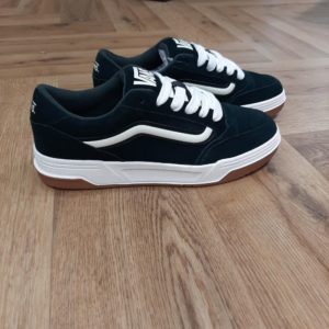 Vans Hylane Scarab Black En effet, les Vans Hylane Scarab Black s'inspirent du skate de l'an 2000 et remettent au goût du jour notre silhouette Upland datant de 1999. Tout d'abord, ces clins d'œil au passé se conjuguent aux détails esthétiques tels que la Sidestripe 3D satinée et les logos brodés. Tandis, que la silhouette épaisse et la languette de skate rembourrée leur confèrent une allure et une sensation rétro. Enfin, elles sont dotées d'une semelle concave et de la texture unique des V imbriqués. En conclusion, les Hylane font de l'esthétique old school un essentiel de ta garde-robe actuelle. Ces chaussures inspirées du skate ont une tige en daim doux pour une tenue durable. Elles possèdent des lacets épais avec un rembourrage spongieux autour du col pour un ajustement confortable et sûr. Avec un amorti léger sous le pied pour un port confortable, elles ont une semelle extérieure en caoutchouc robuste pour une traction adhérente. Finition avec le logo Vans emblématique sur toute la surface. La marque C’est en 1966 que Paul, accompagné de son frère Jim et de ses amis Gordy et Serge, ouvre les portes de la Van Doren Rubber Company au 704 East Broadway à Anaheim, en Californie. Leur façon de travailler est alors unique, vendant leurs chaussures d’où elles sont fabriquées. « Des baskets en toile pour toute la famille » tel était le slogan qu’affichaient les boîtes à chaussures à l’époque.