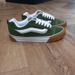 Knu Skool Olive Directement inspirées des années 90, ces chaussures Knu Skool Olive affichent un look contemporain. Les Knu Skool sont une interprétation moderne d'un classique des années 90. Tout d'abord, elles se distinguent par leur languette rembourrée, une Sidestripe moulée en 3D et des lacets épais surdimensionnés. Les Knu Skool s'émancipent des Old Skool originales, véritables icônes classiques, avec des tendances actuelles. Telles qu'une silhouette tapageuse, elles possèdent des renforts couleur gomme et des finitions XXL. En conclusion, les baskets Vans Knu Skool M sont des incontournables du dressing masculin. Parfaites pour une expression individuelle et un look décontracté, ces baskets lifestyle sont idéales pour les hommes en quête d'un style urbain et tendance. La marque C’est en 1966 que Paul, accompagné de son frère Jim et de ses amis Gordy et Serge, ouvre les portes de la Van Doren Rubber Company au 704 East Broadway à Anaheim, en Californie. Leur façon de travailler est alors unique, vendant leurs chaussures d’où elles sont fabriquées. « Des baskets en toile pour toute la famille » tel était le slogan qu’affichaient les boîtes à chaussures à l’époque. C’est le principe novateur de la Van Doren Rubber Company, fondée par ces deux frères originaires de Boston : produire à la commande et sur place, dans la petite usine qui jouxte les 40 m2 du magasin. Et vendre en direct cette chaussure en toile robuste reposant sur une semelle gaufrée en caoutchouc vulcanisé et antidérapante.  Hélas, cette sneaker disparaît brutalement des radars avec la faillite de Vans en 1983. Mais l’histoire de Vans n’écrivait pas son point final. Elle mettra vingt ans à redevenir le signe extérieur d’appartenance à la religion du cool, aux pieds des rockers, des grands ados et des stars d'Hollywood (Justin Bieber, Zac Efron, Harry Styles…). À bientôt 60 ans, cet indéboulonnable totem de la culture skate est aujourd’hui un classique du dressing estival porté flambant neuf à un mariage ou en fin de vie à la plage. Avant de les renouveler les yeux fermés…