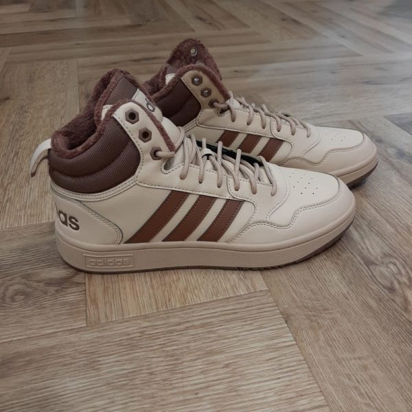 Adidas Hoops Mid Une chaussure inspirée du basketball au style vintage. Donne une touche inspirée du basketball à ton look avec cette chaussure Adidas Hoops Mid. Effectivement, sa tige mi montante en matière synthétique offre un maintien tout en douceur. Tandis que, les 3 bandes classiques et les logos imprimés apportent une touche basketball vintage à ton style. La marque C'est le 18 août 1949 qu'Adi Dassler a démarré l'aventure adidas, avec pour objectif d'améliorer les performances des athlètes. 70 ans plus tard, adidas a laissé sa marque sur le monde du sport, mais aussi celui de la mode, de la musique, de la culture, du développement durable et bien d'autres encore. Voyage avec nous à travers le temps et découvre l'histoire d'adidas avec des modèles qui ont influencé le lifestyle d'aujourd'hui. Juste après la naissance officielle des 3 bandes en 1949, les années 50 ont connu un véritable boom technologique avec des équipements innovants pour les athlètes de classe mondiale. Ainsi, c'est pendant cette décennie qu'est apparue la Samba, toujours portée de nos jours pas les joueurs de Five et de futsal, et toujours présente dans la rue. Pendant les 50's, adidas a développé une chaussure de sprint qui a battu un record du monde et la première chaussure de football conçue avec une semelle en nylon, marquant une vraie nouveauté en termes de confort et de sensations. D'autres modèles ont vu le jour durant cette période, comme la chaussure de basketball Allround, devenue une véritable icône dans les 80's. Ces années ont été révolutionnaires, créant un véritable avant et après pour les sportifs de haut niveau. Mais ce n'était que le début de l'histoire d'adidas.