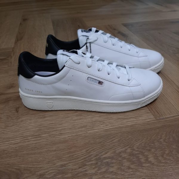 Slammklub White Black La Slammklub CC White Black...La ligne Slamm est axée sur le tennis traditionnel et l'ADN vintage de K-SWISS. Cette slammklub est résolument décontractée et chic design, court de tennis intemporel inspiré des designs classiques. Look et sensations haut de gamme, à porter en toute occasion. Le drapeau des États-Unis célèbre les origines californiennes de la marque. Bienvenue au club. Histoire de la marque K-Swiss a été fondée en 1966, lorsque deux frères suisses se sont installés en Californie pour créer une marque de chaussures axée sur le tennis. Passionnés de ski et de tennis, les frères se sont inspirés des chaussures de ski en cuir pour créer une chaussure de court qui supporte les mouvements latéraux agressifs du tennis. Lancée en 1966, la K-Swiss Classic est la première chaussure de tennis entièrement en cuir. La K-Swiss Classic a rapidement été acclamée dans le monde entier et est devenue une référence en matière de style, tant sur le court qu'en dehors. Plus de 50 ans plus tard, la mission de la marque K-Swiss est d'équiper et d'inspirer la prochaine génération d'entrepreneurs. Ces jeunes leaders sont à l'avant-garde de la culture actuelle, influençant et inspirant les jeunes du monde entier.