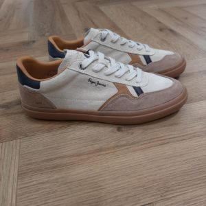 Pepe Jeans Travis Retro Les chaussures Pepe Jeans Travis Retro sont parfaites pour un style décontracté et urbain. Ces chaussures vulcanisées ont une empeigne en croûte de cuir, un col rembourré, notre logo emblématique sur le côté avec des combinaisons de matériaux et de couleurs, une semelle en caoutchouc avec une marque et un logo classique sur le côté. Histoire de la marque En 1973, trois frères Nitin Shah, Arun Shah et Milan Shah, ouvrent une petite « jeanerie » sur le marché de Portobello Road, à l'ouest de Londres, afin de vendre leurs créations. Les frères Shah rencontrent un franc succès, si bien qu'en 1975 ils possèdent quatre boutiques à travers la capitale londonienne. Nous sommes une marque emblématique, synonyme de denim et d'une créativité sans limites . Pepe Jeans London vous offre les bases pour rayonner de confiance en vous, d'unicité et d'authenticité. Dans les années 80, Pepe Jeans est numéro un du marché anglais du jean, devançant ses concurrents américains. C'est ainsi que la marque s’attaque à l’international; aux États-Unis pour commencer où elle implante des bureaux et y ouvre une boutique (1984). L'entreprise Pepe Jeans a ensuite été rachetée par l'espagnol Vicente Castellano en 1989. Les années 1980 seront des années de développement pour l'entreprise. De célèbres groupes tels que les Smiths entrent sous contrat avec la marque pour des campagnes de pub. En 1992, Pepe Jeans introduit son logo actuel.