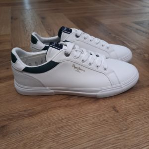 Pepe Jeans Kenton Court Les chaussures Pepe Jeans Kenton Court présentent une combinaison de tissus en toile et en chambray avec une semelle cupsole, qui offre un amorti et un soutien pour les pieds et les chevilles. Le logo est imprimé sur le côté et sur la languette pour ajouter du style aux chaussures. Histoire de la marque En 1973, trois frères Nitin Shah, Arun Shah et Milan Shah, ouvrent une petite « jeanerie » sur le marché de Portobello Road, à l'ouest de Londres, afin de vendre leurs créations. Les frères Shah rencontrent un franc succès, si bien qu'en 1975 ils possèdent quatre boutiques à travers la capitale londonienne. Nous sommes une marque emblématique, synonyme de denim et d'une créativité sans limites . Pepe Jeans London vous offre les bases pour rayonner de confiance en vous, d'unicité et d'authenticité. Dans les années 80, Pepe Jeans est numéro un du marché anglais du jean, devançant ses concurrents américains. C'est ainsi que la marque s’attaque à l’international; aux États-Unis pour commencer où elle implante des bureaux et y ouvre une boutique (1984). L'entreprise Pepe Jeans a ensuite été rachetée par l'espagnol Vicente Castellano en 1989. Les années 1980 seront des années de développement pour l'entreprise. De célèbres groupes tels que les Smiths entrent sous contrat avec la marque pour des campagnes de pub. En 1992, Pepe Jeans introduit son logo actuel.