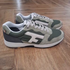 Faguo Olive Kaki Clair La basket Faguo Olive Kaki Clair est une running lifestyle qui combine confort, modernité et respect de l’environnement. Conçue pour un usage urbain et casual, elle s’adapte parfaitement aux besoins de la vie quotidienne grâce à son design ergonomique et sa technologie innovante. Avec des nuances naturelles d’écru et de beige, cette baskets incarne une élégance discrète et polyvalente, idéale pour compléter un look décontracté ou plus soigné. La tige de la basket OLIVE, fabriquée en polyester recyclé, reflète l’engagement de FAGUO pour une mode durable. Les empiècements en cuir suède et PU ajoutent une touche raffinée tout en renforçant la solidité et la structure de la chaussure. Conçue pour épouser naturellement les mouvements du pied, la semelle Flexway, développée par le studio FAGUO, dispose de deux points de flexion à l’avant. Cette innovation assure une démarche fluide et un confort exceptionnel, même après une journée active. La semelle extérieure, en phylon injecté et caoutchouc, combine légèreté et absorption des chocs, garantissant une excellente adhérence sur tous types de surfaces. Les lacets, conçus en polyester recyclé et coton, s’inscrivent dans la démarche écoresponsable de FAGUO, tandis que le packaging recyclé et recyclable renforce cet engagement pour un impact environnemental réduit. En choisissant la basket OLIVE écru et beige, tu fais également un geste pour la planète. Fidèle à sa mission, FAGUO plante des arbres pour compenser ses émissions de carbone, participant activement à la reforestation et à la préservation des écosystèmes. Avec son design épuré, son confort inégalé et son engagement écologique, la basket OLIVE écru et beige représente un choix de style et de valeurs. Ref: S25CG9210 KAK01 La marque Faguo est une marque française créée en 2009 par Frédéric Mugnier et Nicolas Rohr, alors qu'ils étaient encore étudiants et seulement âgés de 22 ans. C'est au cours d'un voyage universitaire en Chine qu'ils vont concevoir le projet Faguo. Il s'agit d'ailleurs d'un nom chinois signifiant tout simplement "France". Dans une démarche de responsabilité sociale et environnementale, ils vont imaginer le principe suivant : pour chaque produit Faguo acheté, un arbre sera planté en France. Et ce premier produit sera une simple tennis en toile ornée d'un bouton en noix de coco, représentant cet engagement. Leur concept va connaître un véritable succès qui va mener la marque à lancer de nouveaux modèles.