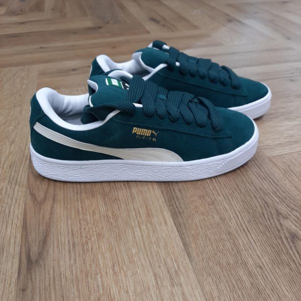 Puma Suede XL Vert-Cette nouvelle version de la légendaire Suede s'inspire de l'héritage de PUMA en matière de breakdance et de son influence sur le streetwear moderne. La Suede XL conserve l'ADN emblématique de la Suede, mais lui donne une nouvelle dimension avec un col et une languette exagérément rembourrés, ainsi qu'une semelle bien plus épaisse. Cette version présente une tige entièrement en suède avec une bande PUMA Formstrip en cuir