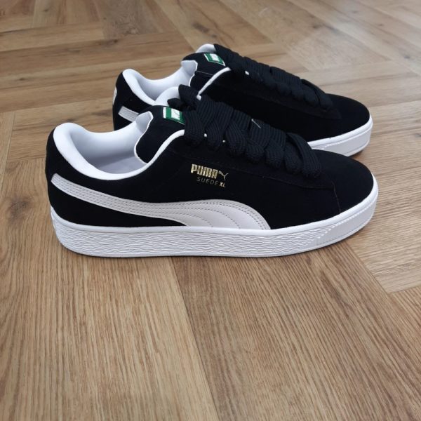 Puma Suede XL Black Cette nouvelle version de la légendaire Puma Suede XL Black s'inspire de l'héritage de PUMA en matière de breakdance et de son influence sur le streetwear moderne. En effet, la Suede XL conserve l'ADN emblématique de la Suede. Mais, lui donne une nouvelle dimension avec un col et une languette exagérément rembourrés, ainsi qu'une semelle bien plus épaisse. De plus, cette version présente une tige entièrement en suède avec une bande PUMA Formstrip en cuir. La marque Puma est une marque de sneakers, de vêtements et d'accessoires de sport créée en Allemagne en 1948. Son origine remonte à 1924, date à laquelle Rudolf Dassler (son créateur) et son frère Adolf (dit "Adi") commencent à fabriquer des baskets de sports. Les deux frères se disputeront et créeront chacun leur marque de leur côté à partir de 1948. Ainsi,  Adi poursuivra l'activité initialement sous le nom d'Adiads et Rudolf créera Puma. La marque au "gros chat" s'illustrera avec ses crampons vissés qui équiperont des sportifs de premier plan. Elle est à l'origine de nombreux modèles de baskets mythiques comme la Puma suede, la Clyde et la Court Star. Plus récemment, Puma a bénéficié d'une exposition exceptionnelle grâce aux exploits d'Usain Bolt qu'elle équipe. Aujourd'hui encore, Puma continue à innover en lançant de nouveaux modèles aux lignes parfois futuristes comme la Blaze, la Mantra, la Tsugi, la RS-X.