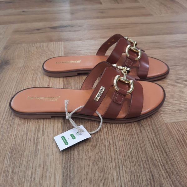 Hamia Tan Craquez pour nos mules Hamia Tan en cuir pour femme moderne. Un modèle iconique de la marque Les Tropeziennes par M. Belarbi. Disponibles en plusieurs coloris, ces mules ajoutent une touche vibrante à votre collection de chaussures. Les brides larges ainsi que son détail doré ajoutent une touche d'élégance naturelle. Elles sont idéales pour vous accompagner durant vos journées actives. Les Tropeziennes par M. Belarbi : L’histoire d’un style intemporel, né à Saint-Tropez. Mo Belarbi, né à Fez, est un créateur visionnaire et passionné par le cuir, l’artisanat et les voyages. En 1975 dans le village emblématique de Saint-Tropez dont il tombe amoureux, il ouvre son premier concept store «La Puce Tropezienne», un lieu unique, foisonnant de créativité et d’audace. Mo Belarbi, esprit libre et innovant y imagine des modèles qui deviendront iconiques, intergénérationnels et s’imposeront rapidement comme incontournables. Des débuts inspirés par les voyages et l’artisanat Dès 1982, inspiré par ses nombreux voyages et les traditions amérindiennes, Mo lance ses premiers modèles à succès : des boots à franges et des mocassins bohèmes. Ces créations, véritables invitations au voyage séduisent immédiatement les artistes, les modeuses, les rêveuses et les globe trotteurs en quête de dolce vita. Une référence intemporelle depuis plus de 40 ans Depuis quatre décennies, Les Tropeziennes par M. Belarbi est devenue la référence numéro un de la sandale en France tout en proposant une gamme de modèles adaptés à toutes les saisons. Fidèle à ses racines tropéziennes, la marque met en lumière un savoir-faire unique, nourri d’influences multiculturelles. Rejoignez notre aventure et portez, vous aussi, l’âme de Saint-Tropez aux quatre coins du monde.