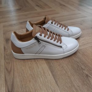 Redskins Souvent Ecru Cette basket Redskins Souvent Ecru en cuir de haute qualité a beaucoup de caractère. Pour commencer, sa fermeture latérale lui assure la praticité dont vous avez besoin. Puis, son coloris écru et cognac sera très facile à accorder à vos tenues. De plus, ces chaussures en cuir sont dotées d'un talon plat. Elle possède une construction soudée et cousu latéral qui allie style et confort. L'histoire de la marque Lorsque l’on parle de la célèbre marque de cuir Redskins, on pense immédiatement au look américain, au style biker avec ce petit côté rock’n roll qui souligne la tenue masculine. Or c’est bel et bien en France qu’est née la marque, créée par Serge ABOUJEDID. C’est donc en 1984 que la marque Redskins voit le jour, inspirée de la culture américaine et de la tendance rock’n roll, empreint d’une touche contemporaine dans chaque création de la marque. Cette marque résolument française est née à Gennevilliers et oriente ses collections vers la fabrication de blousons et vestes en cuir pour homme. A partir des année 90, la marque a mis au gout du jour le modèle teddy Redskins, qui n’a de cesse d’être la pièce indémodable de votre garde-robe. Aujourd’hui, stylistes et créateurs ont choisi de diversifier leur gamme pour proposer des chaussures en cuir Redskins, la maroquinerie et divers accessoires à la vente. Une stratégie payante puisque la marque devient aujourd’hui la référence du cuir de qualité. Toujours enclin à suivre le mouvement culturel et notamment cinématographique, Redskins n’hésite pas à s’associer à des personnalités influentes pour proposer ses créations au grand public. Shemar Moore, David Duchovny ou encore Johnny Hallyday ont fait partie de leur figure pour représenter leur collection.