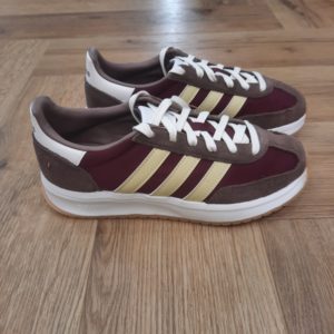 Adidas Run 70: Une sneaker classique et polyvalente pour le quotidien Conçue pour durer, cette sneaker Adidas Run 70 est stylée et intemporelle. En effet, sa tige en cuir souple est doublée pour plus de confort. Puis, elle est associée à une semelle extérieure en caoutchouc flexible idéale quand tu es constamment en mouvement. De plus l'amorti Cloudfoam te procure un confort durable tandis que tu fais tes courses en ville ou prends un café. La marque C'est le 18 août 1949 qu'Adi Dassler a démarré l'aventure adidas, avec pour objectif d'améliorer les performances des athlètes. 70 ans plus tard, adidas a laissé sa marque sur le monde du sport, mais aussi celui de la mode, de la musique, de la culture, du développement durable et bien d'autres encore. Voyage avec nous à travers le temps et découvre l'histoire d'adidas avec des modèles qui ont influencé le lifestyle d'aujourd'hui. Juste après la naissance officielle des 3 bandes en 1949, les années 50 ont connu un véritable boom technologique avec des équipements innovants pour les athlètes de classe mondiale. Ainsi, c'est pendant cette décennie qu'est apparue la Samba, toujours portée de nos jours pas les joueurs de Five et de futsal, et toujours présente dans la rue. Pendant les 50's, adidas a développé une chaussure de sprint qui a battu un record du monde et la première chaussure de football conçue avec une semelle en nylon, marquant une vraie nouveauté en termes de confort et de sensations. D'autres modèles ont vu le jour durant cette période, comme la chaussure de basketball Allround, devenue une véritable icône dans les 80's. Ces années ont été révolutionnaires, créant un véritable avant et après pour les sportifs de haut niveau. Mais ce n'était que le début de l'histoire d'adidas.