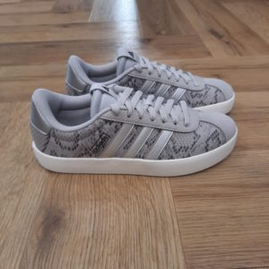 Adidas VL Court Cette sneaker Adidas VL Court présente une tige en matière synthétique souple et un avant-pied en T classique. Pour commencer, la semelle cupsole en caoutchouc et les 3 bandes contrastées ajoutent une touche sport. De plus, ce produit contient au moins 20 % de matières recyclées. En effet, en réutilisant des matériaux déjà existants, nous contribuons à réduire les déchets, notre dépendance aux ressources limitées et l’empreinte écologique des produits que nous fabriquons. Un look classique et épuré est toujours tendance.  La marque C'est le 18 août 1949 qu'Adi Dassler a démarré l'aventure adidas, avec pour objectif d'améliorer les performances des athlètes. 70 ans plus tard, adidas a laissé sa marque sur le monde du sport, mais aussi celui de la mode, de la musique, de la culture, du développement durable et bien d'autres encore. Voyage avec nous à travers le temps et découvre l'histoire d'adidas avec des modèles qui ont influencé le lifestyle d'aujourd'hui. Juste après la naissance officielle des 3 bandes en 1949, les années 50 ont connu un véritable boom technologique avec des équipements innovants pour les athlètes de classe mondiale. Ainsi, c'est pendant cette décennie qu'est apparue la Samba, toujours portée de nos jours pas les joueurs de Five et de futsal, et toujours présente dans la rue. Pendant les 50's, adidas a développé une chaussure de sprint qui a battu un record du monde et la première chaussure de football conçue avec une semelle en nylon, marquant une vraie nouveauté en termes de confort et de sensations. D'autres modèles ont vu le jour durant cette période, comme la chaussure de basketball Allround, devenue une véritable icône dans les 80's. Ces années ont été révolutionnaires, créant un véritable avant et après pour les sportifs de haut niveau. Mais ce n'était que le début de l'histoire d'adidas.
