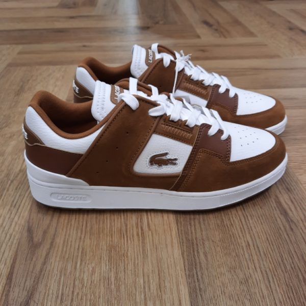 Lacoste Court Cage Inspirée des archives tennis la Lacoste Court Cage est une silhouette lifestyle élégante. Elle se distingue par une tige en cuir aux empiècements harmonieux, relevée de détails venus des courts à l’image de perforations et d’un renfort de talon en TPU. Un crocodile signature brodé finalise son design entre mode et sport. La marque Créée par la légende du tennis français René Lacoste, quatre fois vainqueur d’internationaux et 1er joueur mondial en 1926 et 1927, la marque Lacoste s’inspire de ses valeurs sportives : exigence, fair-play, audace. Nous les transmettons de génération en génération, et cultivons l’élégance comme une manière d’être et d’inventer sa vie. Le jeu d’équipe, l’audace et l’inventivité, l’élégance et la ténacité sont autant de valeurs que nous prisons afin de continuer à écrire, ensemble, l’histoire de Lacoste. Pour aider les talents qui nous rejoignent à développer leur plein potentiel, nous favorisons une culture d’entreprise inclusive, qui fait la part belle à l’épanouissement personnel et professionnel, ainsi qu’à une montée en compétence régulière. En tant qu’acteur responsable de la mode, nous nous impliquons pour créer et mettre en œuvre un nouveau modèle de mode durable : une démarche de co-construction innovante et ambitieuse, dans laquelle nous engageons l’ensemble de nos partenaires. Notre modèle prend en compte la totalité de notre impact écologique, ainsi que celui de nos fournisseurs et propose une alternative, l’élégance durable, qui bénéficie à la fois à l’humain, aux communautés locales qui la produisent et à la planète.