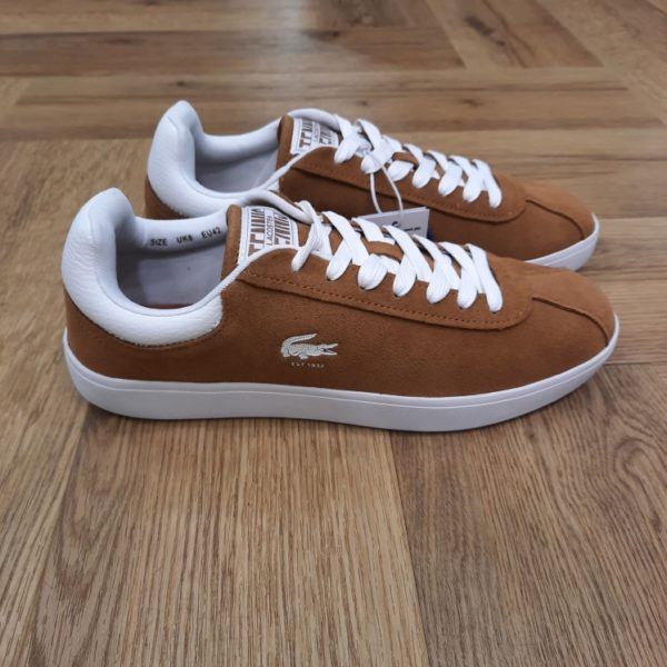 Lacoste Baseshot Camel La sneaker Lacoste Baseshot Camel incarne le classicisme avec sa tige en suède pelucheux et un crocodile imprimé et débossé. En effet, sa palette de couleurs automnale est une évocation subtile de l'héritage Lacoste. Elle sera parfaite en toutes circonstances. La marque Créée par la légende du tennis français René Lacoste, quatre fois vainqueur d’internationaux et 1er joueur mondial en 1926 et 1927, la marque Lacoste s’inspire de ses valeurs sportives : exigence, fair-play, audace. Nous les transmettons de génération en génération, et cultivons l’élégance comme une manière d’être et d’inventer sa vie. Le jeu d’équipe, l’audace et l’inventivité, l’élégance et la ténacité sont autant de valeurs que nous prisons afin de continuer à écrire, ensemble, l’histoire de Lacoste. Pour aider les talents qui nous rejoignent à développer leur plein potentiel, nous favorisons une culture d’entreprise inclusive, qui fait la part belle à l’épanouissement personnel et professionnel, ainsi qu’à une montée en compétence régulière. En tant qu’acteur responsable de la mode, nous nous impliquons pour créer et mettre en œuvre un nouveau modèle de mode durable : une démarche de co-construction innovante et ambitieuse, dans laquelle nous engageons l’ensemble de nos partenaires. Notre modèle prend en compte la totalité de notre impact écologique, ainsi que celui de nos fournisseurs et propose une alternative, l’élégance durable, qui bénéficie à la fois à l’humain, aux communautés locales qui la produisent et à la planète.