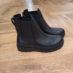 Pallagrade Chelsea Boots La Pallagrade Chelsea Boots, cette version raffinée de la botte Chelsea classique marie l'ADN de Palladium à une sophistication moderne. Confectionnée en cuir nappa souple, elle est équipée d’une semelle extérieure conçue pour un ajustement parfait, avec des crampons et un contour en losanges pour une combinaison idéale de durabilité et d’élégance. Les détails soignés comme les empiècements élastiques et la languette au talon ajoutent une touche chic à ce modèle polyvalent. Un indispensable élégant pour toutes les occasions. Palladium est une marque française qui propose depuis quelques décennies des chaussures en toile et en caoutchouc résistantes et durables. Avec des origines militaires et une forme bien reconnaissable, les Palladium traversent les générations sans prendre une ride (ou presque). Palladium est une marque française créée en 1920. À l'origine, son activité est bien différente de celle que l'on connait aujourd'hui : Palladium fabriquait des pneus pour l'aviation. La société fournissait alors la plupart des flottes aériennes européennes grâce à un procédé industriel unique : la vulcanisation du caoutchouc et de la toile. Au lendemain de la Seconde Guerre Mondiale, Palladium cesse peu à peu cette activité. En 1947, la société ouvre une usine à Pont de Cheruy, dans l'Isère, où elle commence à produire des chaussures selon le même principe de vulcanisation. Chaussures qui se révéleront tout aussi solides ! Le modèle emblématique de la marque est le "Pampa" qui équipe notamment la légion étrangère française