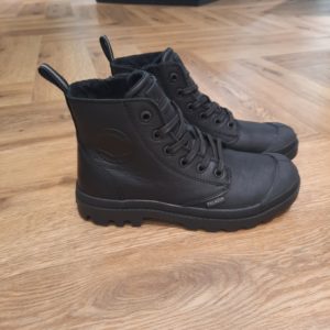 Pampa Hi Zip Black L’originale de Palladium depuis 1947. L’iconique Pampa Hi Zip Black en cuir classique et souple, munie d’une fermeture éclair sur la partie médiane pour l’enfiler et la retirer facilement. Un modèle essentiel et intemporel qui se distingue par sa polyvalence. À associer à n’importe quelle tenue. Un classique pour explorateurs audacieux. Palladium est une marque française qui propose depuis quelques décennies des chaussures en toile et en caoutchouc résistantes et durables. Avec des origines militaires et une forme bien reconnaissable, les Palladium traversent les générations sans prendre une ride (ou presque). Palladium est une marque française créée en 1920. À l'origine, son activité est bien différente de celle que l'on connait aujourd'hui : Palladium fabriquait des pneus pour l'aviation. La société fournissait alors la plupart des flottes aériennes européennes grâce à un procédé industriel unique : la vulcanisation du caoutchouc et de la toile. Au lendemain de la Seconde Guerre Mondiale, Palladium cesse peu à peu cette activité. En 1947, la société ouvre une usine à Pont de Cheruy, dans l'Isère, où elle commence à produire des chaussures selon le même principe de vulcanisation. Chaussures qui se révéleront tout aussi solides ! Le modèle emblématique de la marque est le "Pampa" qui équipe notamment la légion étrangère française