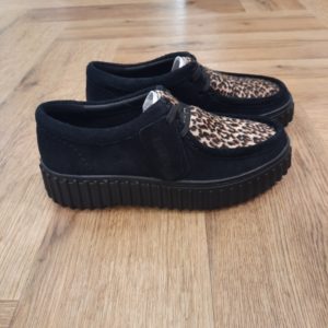 Clarks Torhill Bee Léopard L’audacieuse semelle extérieure côtelée qui caractérise la Clarks Torhill Bee Léopard est issue de nos archives, mais elle est tout aussi contemporaine aujourd’hui que dans notre modèle Big Gripper (chaussures à crampons) des années 90. Avec un design à lacets épuré dont les courbes et les contours s’inspirent de notre emblématique Wallabee, elle associe du daim à imprimé léopard haut de gamme à des surpiqûres raffinées pour créer la chaussure décontractée ultime inspirée de notre histoire. Nos fondateurs Notre histoire a commencé en 1825 à Street, dans le Somerset, lorsque Cyrus Clark a ouvert une tannerie de cuir, son frère James travaillant à ses côtés. Parmi les tapis en peau de mouton, James a eu un éclair d'inspiration : utiliser les chutes pour créer des pantoufles - minimiser les déchets, maximiser l'ingéniosité et définir les 200 prochaines années de la fabrication de chaussures. Chaque chaussure Clarks, depuis notre toute première paire, utilise cette combinaison distinctive d'innovation et de savoir-faire, soutenant tout ce que nous faisons. Depuis 200 ans, nous avons défini la norme - et ce n'est que le début. En 2025, nous rendons hommage au passé et au présent et célébrons fièrement cet héritage de deux siècles d'innovation et d'impact à travers un tout nouveau film, un livre, une exposition de musée et des collaborations de style.