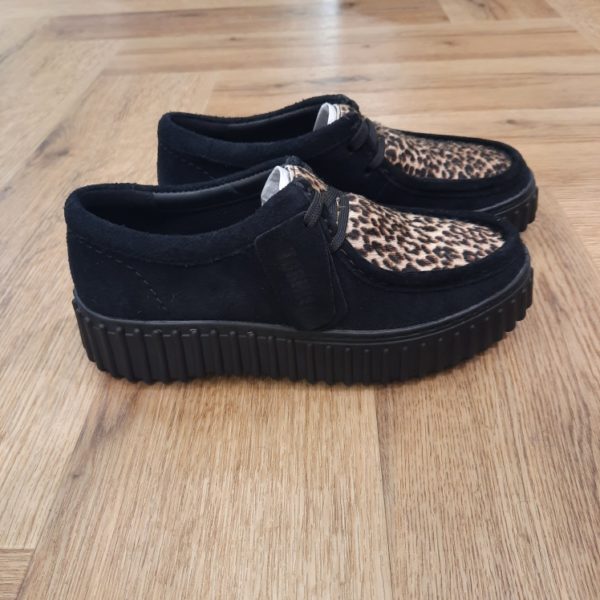 Clarks Torhill Bee Léopard L’audacieuse semelle extérieure côtelée qui caractérise la Clarks Torhill Bee Léopard est issue de nos archives, mais elle est tout aussi contemporaine aujourd’hui que dans notre modèle Big Gripper (chaussures à crampons) des années 90. Avec un design à lacets épuré dont les courbes et les contours s’inspirent de notre emblématique Wallabee, elle associe du daim à imprimé léopard haut de gamme à des surpiqûres raffinées pour créer la chaussure décontractée ultime inspirée de notre histoire. Nos fondateurs Notre histoire a commencé en 1825 à Street, dans le Somerset, lorsque Cyrus Clark a ouvert une tannerie de cuir, son frère James travaillant à ses côtés. Parmi les tapis en peau de mouton, James a eu un éclair d'inspiration : utiliser les chutes pour créer des pantoufles - minimiser les déchets, maximiser l'ingéniosité et définir les 200 prochaines années de la fabrication de chaussures. Chaque chaussure Clarks, depuis notre toute première paire, utilise cette combinaison distinctive d'innovation et de savoir-faire, soutenant tout ce que nous faisons. Depuis 200 ans, nous avons défini la norme - et ce n'est que le début. En 2025, nous rendons hommage au passé et au présent et célébrons fièrement cet héritage de deux siècles d'innovation et d'impact à travers un tout nouveau film, un livre, une exposition de musée et des collaborations de style.