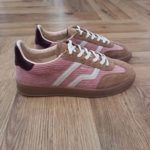 Gant Cuzima Velours La chaussure Gant Cuzima Velours est une paire de baskets d'inspiration rétro, qui se porte en toute saison. Tout d'abord, elles sont dotées d'une tige en cuir de qualité supérieure. De plus, elles arborent des finitions de couleur contrastante au niveau du bout, du talon et sur le côté. Puis, sa fine semelle extérieure en caoutchouc et la doublure en coton éponge apportent un style vintage à l'ensemble. Les baskets Gant Cuzima pour femme sont la fusion parfaite entre style rétro et confort. Avec leur design intemporel et leurs matériaux de qualité supérieure, elles sont idéales pour toute occasion. Elles garantissent un look décontracté et moderne qui ne passera pas inaperçu. La marque Quand Bernard Gant, un immigrant ukrainien, arrive à New-York en 1914, il se plonge directement au cœur des métiers du prêt-à-porter. Il travaille dans un atelier de confection de chemises dans le centre de la ville. Ce n'est que quelques années plus tard, alors qu'il a déménagé à New Haven dans le Connecticut qu'il lancera l'entreprise familiale à l'aide de sa femme, également dans le métier. Rapidement, il fabrique des chemises pour les plus grandes marques du pays tel que Brooks Brothers. Si le style de Gant a beaucoup évolué au cours des années, il ne s'est jamais vraiment détaché de son image de marque Américaine traditionnelle. En effet, adepte du style Ivy avec comme produit phare la chemise à col boutonné. Après avoir été suédoise, la marque a été rachetée en 2008 par le groupe suisse Maus Frères, qui détient entre autres Lacoste et Aigle, mais elle garde encore ses valeurs originelles : celles de Bernard Gant.