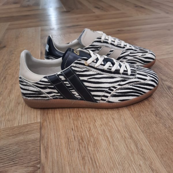Pulse Zebra Obession-sneakers femme caval zebra obsession-Le modèle de basket écoresponsable Pulse sont des sneakers asymétriques qui mélangent un look sportswear à l'élégance des paires de handball des années 90. Un modèle retro et confortable couleur honey espresso ! Elles sont confectionnées entièrement en Europe, au Portugal, avec des matériaux éco-responsables, traçables et labellisés. Chaque détail, du bout golf, à la plaque perforée, en passant par les découpes croquet, le cousu Strobel, le lacet tricot et les semelles en gomme affûtées, évoque un style rétro-preppy sophistiqué. Souples et flexibles, elles promettent confort et allure pour toutes vos tenues. Trouvez les 7 différences !