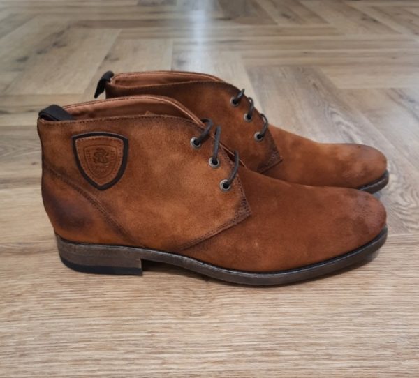Redskins Boots Hickory Si vous êtes à la recherche de boots et/ou bottines pour hommes alliant élégance et praticité, vous êtes au bon endroit ! Les Redskins Boots Hickory en cuir pour hommes sont un élément incontournable du vestiaire masculin. Elles se distinguent par leur polyvalence, leur style intemporel et leur qualité exceptionnelle. Le cuir, la matière principale des boots REDSKINS Les boots en cuir REDSKINS sont réalisées avec soin et se déclinent en plusieurs matériaux, formes et semelles pour répondre à vos envies. Chaque saison, elles se réinventent tout en restant intemporelles, combinant élégance et confort. Le cuir demande un bon entretien, veillez à bien nettoyer vos chaussures pour les préserver. Boots en Cuir Suédé Homme REDSKINS Qu'est-ce que des bottes en cuir suédé ? Le cuir suédé, c'est le cuir qui n'est pas utilisé du côté lisse. Il est aussi appelé croûte velours ou bien plus communément daim, mais le cuir provient bien d'un cuir de bovin. Ces boots en cuir suédé sont à la fois urbaines et tendance, et confère un look plus casual. Disponibles dans des teintes sobres telles que le marron ou le beige, elles s'harmonisent parfaitement avec une grande variété de styles.