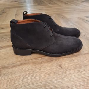 Kost Wesley Chataigne Découvrez l’élégance intemporelle des desert boots Kost Wesley en cuir suédé couleur châtaigne. D'abord, elles sont conçues avec une ligne épurée et un laçage minimaliste à 3 œillets. En effet, elles associent confort et raffinement. De plus, leur semelle fine et robuste assure une allure distinguée tout en offrant une bonne résistance au quotidien. Puis, polyvalentes, elles s’adaptent aussi bien à une tenue habillée qu’à un style casual chic. Pour conclure, c'est la chaussure incontournable pour l’homme moderne qui recherche authenticité et style. La marque Kost La marque s'est lancée dans l’aventure en 2010. Trimballés entre Paris et notre région d’origine près de Cholet, entre les concerts rock et les usines de fabrication de chaussures, nous avions à cœur de concilier une certaine classe avec des codes vintage, pour proposer des collections originales au look soigné. Nous puisons notre inspiration dans la culture rock des années 70 en vivant dans notre siècle, et nous tentons de faire notre part pour améliorer sans cesse notre chaîne de production. Nous proposons des chaussures de ville et des sneakers fabriquées avec une attention particulière sur la qualité des matériaux, le confort et la technique de fabrication. Nous minimisons autant que possible notre empreinte environnementale. Nous proposons des pièces intemporelles et originales qui durent dans le temps.