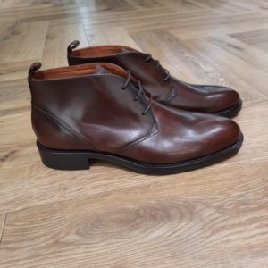 Kost Wesley Cognac Découvrez l’élégance intemporelle des desert boots Kost Wesley en cuir couleur cognac. D'abord, elles sont conçues avec une ligne épurée et un laçage minimaliste à 3 œillets. En effet, elles associent confort et raffinement. De plus, leur semelle fine et robuste assure une allure distinguée tout en offrant une bonne résistance au quotidien. Puis, polyvalentes, elles s’adaptent aussi bien à une tenue habillée qu’à un style casual chic. Pour conclure, c'est la chaussure incontournable pour l’homme moderne qui recherche authenticité et style. La marque Kost La marque s'est lancée dans l’aventure en 2010. Trimballés entre Paris et notre région d’origine près de Cholet, entre les concerts rock et les usines de fabrication de chaussures, nous avions à cœur de concilier une certaine classe avec des codes vintage, pour proposer des collections originales au look soigné. Nous puisons notre inspiration dans la culture rock des années 70 en vivant dans notre siècle, et nous tentons de faire notre part pour améliorer sans cesse notre chaîne de production. Nous proposons des chaussures de ville et des sneakers fabriquées avec une attention particulière sur la qualité des matériaux, le confort et la technique de fabrication. Nous minimisons autant que possible notre empreinte environnementale. Nous proposons des pièces intemporelles et originales qui durent dans le temps.