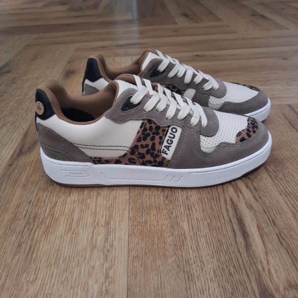 Faguo Ceiba Léopard Un motif audacieux, une ligne rétro. Les baskets CEIBA écrues, beige foncé et léopard revisitent les années 90 avec caractère. Pensées pour bouger. Conçues pour durer. Ces baskets léopard sont montées sur une semelle épaisse en caoutchouc cousu latéral. Un choix technique pour le confort et la résistance. La tige associe cuir, suède, textile et PU. Le tout dans un équilibre de tons neutres relevés par le motif léopard. À l’intérieur, la doublure en polyester recyclé accompagne chaque pas. Les lacets en coton assurent une finition sobre. Ces baskets léopard s’associent facilement à une jupe longue, un denim brut ou un pantalon fluide. La marque Faguo est une marque française créée en 2009 par Frédéric Mugnier et Nicolas Rohr, alors qu'ils étaient encore étudiants et seulement âgés de 22 ans. C'est au cours d'un voyage universitaire en Chine qu'ils vont concevoir le projet Faguo. Il s'agit d'ailleurs d'un nom chinois signifiant tout simplement "France". Dans une démarche de responsabilité sociale et environnementale, ils vont imaginer le principe suivant : pour chaque produit Faguo acheté, un arbre sera planté en France. Et ce premier produit sera une simple tennis en toile ornée d'un bouton en noix de coco, représentant cet engagement. Leur concept va connaître un véritable succès qui va mener la marque à lancer de nouveaux modèles.