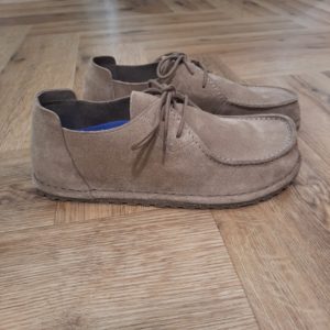 Utti Lace Suède-birkenstock utti lace taupe-Prendre soin de vos chaussures Birkenstock n'est pas compliqué, mais nécessite quelques bonnes habitudes pour préserver l'éclat et la qualité de vos chaussures. - Pour les modèles en cuir: Utilisez un linge légèrement humidifié pour frotter délicatement les taches. Attention à ne pas trop imbiber la chaussure d'eau, car elle pourrait endommager le cuir. Pour les taches tenaces, une brosse à poils doux fera l'affaire. - Pour les modèles en daim : Le daim est une matière plus délicate, donc oubliez l'eau ! Celle-ci pourrait laisser des traces irréversibles. Optez plutôt pour des produits de nettoyage spécialement conçus pour le daim. Vous en trouverez facilement en ligne, par exemple chez UGG.