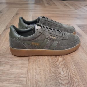 Gola Hawk Kaki La toute nouvelle Gola Hawk Kaki rejoint la gamme emblématique. En effet, le modèle authentique Hawk est revisité avec une tige en daim de qualité couleur tabac et une semelle en gomme. Tout d'abord, son style chaleureux et décontracté dégage une touche vintage. En effet, c'est le complément idéal de toute garde-robe, pour un usage quotidien et pour donner du caractère à toutes vos tenues. La marque Gola est une marque principalement connue pour ses chaussures de sport. Elle a été créé en 1905 à Leicester, au Royaume Uni. Pour l'anecdote, personne ne sait exactement d'où vient le nom de la marque. Pourtant, une légende urbaine raconte qu'elle doit son nom à l'anagramme du mot "Goal" (qui signifie "but" en anglais). La marque commence à être connue à la fin des années 1960. Notamment dans le sport notamment avec la Harrier qui reste aujourd'hui encore le modèle phare de la marque anglaise. En effet, elle a très vite été adoptée par le grand public. Fort de son histoire, la marque a su traverser les générations et est aujourd'hui une marque streetwear à part entière qui sait innover et suivre les tendances. On a d'ailleurs pu voir une collection 100 % vegan sortir des tuyaux en 2019, preuve de la capacité de Gola à s'adapter au marché actuel !