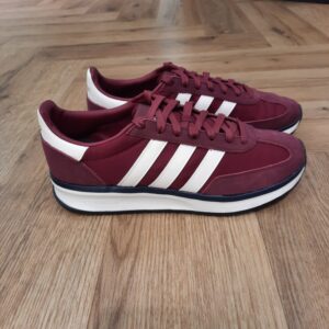 Run 70 Bordeau Apporte une touche seventies à ton look quotidien avec cette sneaker Adidas Run 70 Bordeau. Sa tige légère est doublée pour plus de douceur, tandis que l’amorti Cloudfoam t'aide à effectuer toutes tes activités confortablement. De ton café matinal à une soirée entre amis, cette paire ira avec toutes tes tenues. La semelle extérieure en caoutchouc souple te permet de bouger avec confiance, quel que soit le programme. La marque C'est le 18 août 1949 qu'Adi Dassler a démarré l'aventure adidas, avec pour objectif d'améliorer les performances des athlètes. 70 ans plus tard, adidas a laissé sa marque sur le monde du sport, mais aussi celui de la mode, de la musique, de la culture, du développement durable et bien d'autres encore. Voyage avec nous à travers le temps et découvre l'histoire d'adidas avec des modèles qui ont influencé le lifestyle d'aujourd'hui. Juste après la naissance officielle des 3 bandes en 1949, les années 50 ont connu un véritable boom technologique avec des équipements innovants pour les athlètes de classe mondiale. Ainsi, c'est pendant cette décennie qu'est apparue la Samba, toujours portée de nos jours pas les joueurs de Five et de futsal, et toujours présente dans la rue. Pendant les 50's, adidas a développé une chaussure de sprint qui a battu un record du monde et la première chaussure de football conçue avec une semelle en nylon, marquant une vraie nouveauté en termes de confort et de sensations. D'autres modèles ont vu le jour durant cette période, comme la chaussure de basketball Allround, devenue une véritable icône dans les 80's. Ces années ont été révolutionnaires, créant un véritable avant et après pour les sportifs de haut niveau. Mais ce n'était que le début de l'histoire d'adidas