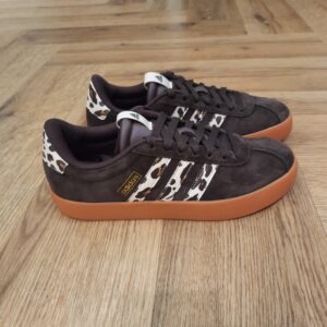 VL Court Marron Léopard Cette sneaker Adidas VL Court Marron Léopard est conçue en cuir souple et doublée pour plus de confort. L'amorti léger t'offre le maintien dont tu as besoin pendant les journées actives. Elle possède une semelle extérieure en caoutchouc vulcanisé pour plus de souplesse et un style d'inspiration skate. La marque C'est le 18 août 1949 qu'Adi Dassler a démarré l'aventure adidas, avec pour objectif d'améliorer les performances des athlètes. 70 ans plus tard, adidas a laissé sa marque sur le monde du sport, mais aussi celui de la mode, de la musique, de la culture, du développement durable et bien d'autres encore. Voyage avec nous à travers le temps et découvre l'histoire d'adidas avec des modèles qui ont influencé le lifestyle d'aujourd'hui. Juste après la naissance officielle des 3 bandes en 1949, les années 50 ont connu un véritable boom technologique avec des équipements innovants pour les athlètes de classe mondiale. Ainsi, c'est pendant cette décennie qu'est apparue la Samba, toujours portée de nos jours pas les joueurs de Five et de futsal, et toujours présente dans la rue. Pendant les 50's, adidas a développé une chaussure de sprint qui a battu un record du monde et la première chaussure de football conçue avec une semelle en nylon, marquant une vraie nouveauté en termes de confort et de sensations. D'autres modèles ont vu le jour durant cette période, comme la chaussure de basketball Allround, devenue une véritable icône dans les 80's. Ces années ont été révolutionnaires, créant un véritable avant et après pour les sportifs de haut niveau. Mais ce n'était que le début de l'histoire d'adidas.