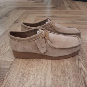 Clarks Wallabee Evo Beige En élargissant la famille, notre Clarks Wallabee Evo Beige arrive en daim intemporel pour une utilisation polyvalente toute la saison. Une tige en cuir ultra-doux apporte un look et une sensation haut de gamme, tandis que sa semelle à effet crêpe reste tonale pour une esthétique élégante et discrète. Avec une semelle intérieure super confortable et une semelle adhérente, cette paire garantit des pas légers encore et encore. Nos fondateurs Notre histoire a commencé en 1825 à Street, dans le Somerset, lorsque Cyrus Clark a ouvert une tannerie de cuir, son frère James travaillant à ses côtés. Parmi les tapis en peau de mouton, James a eu un éclair d'inspiration : utiliser les chutes pour créer des pantoufles - minimiser les déchets, maximiser l'ingéniosité et définir les 200 prochaines années de la fabrication de chaussures. Chaque chaussure Clarks, depuis notre toute première paire, utilise cette combinaison distinctive d'innovation et de savoir-faire, soutenant tout ce que nous faisons. Depuis 200 ans, nous avons défini la norme - et ce n'est que le début. En 2025, nous rendons hommage au passé et au présent et célébrons fièrement cet héritage de deux siècles d'innovation et d'impact à travers un tout nouveau film, un livre, une exposition de musée et des collaborations de style.