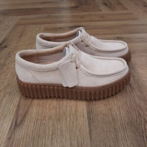 Clarks Torhill Bee Ecru La semelle extérieure audacieuse et nervurée qui définit notre chaussure Clarks Torhill Bee Ecru provient de nos archives mais paraît tout aussi contemporaine aujourd’hui qu’elle l’était dans notre profil Big Gripper des années 90. Avec un design profilé et lacé qui reflète ses courbes et contours sur notre célèbre Wallabee™, il combine des matériaux haut de gamme avec des détails soignés comme des coutures complexes pour créer la chaussure décontractée ultime et inspirée de l’héritage. 200 ans de confort Depuis 200 ans, nous avons défini la norme - et ce n'est que le début. En 2025, nous rendons hommage au passé et au présent et célébrons fièrement cet héritage de deux siècles d'innovation et d'impact à travers un tout nouveau film, un livre, une exposition de musée et des collaborations de style. Nos fondateurs Notre histoire a commencé en 1825 à Street, dans le Somerset, lorsque Cyrus Clark a ouvert une tannerie de cuir, son frère James travaillant à ses côtés. Parmi les tapis en peau de mouton, James a eu un éclair d'inspiration : utiliser les chutes pour créer des pantoufles - minimiser les déchets, maximiser l'ingéniosité et définir les 200 prochaines années de la fabrication de chaussures. Chaque chaussure Clarks, depuis notre toute première paire, utilise cette combinaison distinctive d'innovation et de savoir-faire, soutenant tout ce que nous faisons.