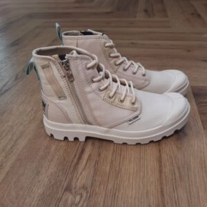 Pampa Détroit Zip Puisant son inspiration dans les codes militaires et l’héritage ouvrier de Detroit, le modèle Pampa Détroit Zip associe fonctionnalité, caractère et modernité. Conçue en sergé coton biologique résistant, la chaussure Pampa Détroit Zip séduit par ses contrastes de couleurs originaux et sa fermeture latérale zippée, tandis que sa semelle emblématique assure confort et liberté de mouvement, en ville comme en randonnées. La marque Palladium est une marque française qui propose depuis quelques décennies des chaussures en toile et en caoutchouc résistantes et durables. Avec des origines militaires et une forme bien reconnaissable, les Palladium traversent les générations sans prendre une ride (ou presque). Palladium est une marque française créée en 1920. À l'origine, son activité est bien différente de celle que l'on connait aujourd'hui : Palladium fabriquait des pneus pour l'aviation. La société fournissait alors la plupart des flottes aériennes européennes grâce à un procédé industriel unique : la vulcanisation du caoutchouc et de la toile. Au lendemain de la Seconde Guerre Mondiale, Palladium cesse peu à peu cette activité. En 1947, la société ouvre une usine à Pont de Cheruy, dans l'Isère, où elle commence à produire des chaussures selon le même principe de vulcanisation. Chaussures qui se révéleront tout aussi solides ! Le modèle emblématique de la marque est le "Pampa" qui équipe notamment la légion étrangère française