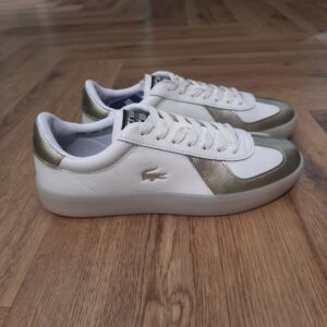 Baseshot White Gold La Baseshot White Gold est une nouvelle version de la Baseshot Pro qui apporte un vent de fraîcheur et de nouveauté. La tige en cuir se prolonge à l'avant par un embout également en cuir, le crocodile marqué en creux sur le côté rend en hommage à l'héritage Lacoste. La marque Créée par la légende du tennis français René Lacoste, quatre fois vainqueur d’internationaux et 1er joueur mondial en 1926 et 1927, la marque Lacoste s’inspire de ses valeurs sportives : exigence, fair-play, audace. Nous les transmettons de génération en génération, et cultivons l’élégance comme une manière d’être et d’inventer sa vie. Le jeu d’équipe, l’audace et l’inventivité, l’élégance et la ténacité sont autant de valeurs que nous prisons afin de continuer à écrire, ensemble, l’histoire de Lacoste. Pour aider les talents qui nous rejoignent à développer leur plein potentiel, nous favorisons une culture d’entreprise inclusive, qui fait la part belle à l’épanouissement personnel et professionnel, ainsi qu’à une montée en compétence régulière.