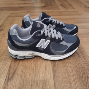 New Balance 2002RSF La structure d'empeigne de qualité supérieure de cette sneaker New Balance 2002RSF  offre une version améliorée d'un style classique. La création de New Balance L’histoire de New Balance débute en 1906 à Boston, sous l’impulsion de William J. Riley, un immigrant britannique soucieux d’améliorer le confort des chaussures orthopédiques. Inspiré par l’équilibre parfait des pattes de poulet, il développe une semelle révolutionnaire dotée de trois points d’appui, destinée à offrir un soutien optimal. Dans les années 1930, la société commence à produire des chaussures de sport sur mesure, attirant l’attention des coureurs et des athlètes professionnels. Le véritable tournant survient en 1960 avec le lancement de la Trackster, première chaussure de running à semelle ondulée, qui se décline en plusieurs largeurs pour un ajustement personnalisé. Ce succès pose les bases de l’identité de New Balance : innovation, performance et fabrication locale. Les produits emblématiques de New Balance Depuis ses débuts, New Balance a développé des modèles devenus iconiques. Parmi eux, la New Balance 574, lancée en 1988, reste l’une des plus populaires. Conçue à l’origine pour la course à pied, elle s’impose rapidement comme une chaussure lifestyle incontournable, grâce à son design polyvalent et son confort exceptionnel. Autre modèle phare, la New Balance 990, introduite en 1982, marque un tournant en devenant la première chaussure de running à dépasser la barre des 100 dollars. Plébiscitée autant par les coureurs professionnels que par les amateurs de sneakers, elle incarne le parfait équilibre entre performance et style premium. Dans la même veine, la New Balance 327, inspirée des modèles des années 70, a su conquérir un public jeune et branché, notamment grâce à ses nombreuses collaborations avec des marques de mode.