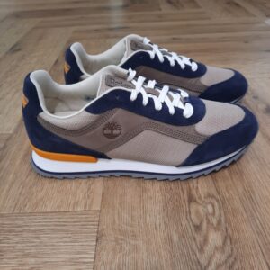 Basket Scout Heights-baskets et sneakers timberland pour homme-L’histoire de Timberland L’histoire des Timberland Boots remonte à la ville de Newmarket, dans le New Hampshire, aux États-Unis, où elles ont été créées en 1973. À l’origine, elles étaient destinées aux travailleurs du bâtiment et des espaces extérieurs. Les fondateurs, Nathan Swartz et sa famille, ont mis l’accent sur la qualité et la durabilité dès le départ. C’est ainsi que les premières Timberland Boots sont nées, dotées de coutures étanches, d’une semelle crantée pour une meilleure adhérence, et d’un cuir de première qualité. Cette combinaison de caractéristiques en a rapidement fait des chaussures de choix pour les travailleurs et les amateurs de plein air. Au fil des années, les Timberland Boots ont conquis un public plus large. Elles sont devenues un élément essentiel du style urbain, notamment dans le mouvement hip-hop des années 90, où elles ont été adoptées comme symbole de résilience et de style. Le nom « Timberland » lui-même évoque des images de forêts, de montagnes et d’aventures en plein air, ce qui en fait un choix idéal pour les esprits aventuriers. Ce qui rend les Timberland Boots uniques Plus de quatre décennies après leur création, les Timberland Boots continuent de séduire de nombreux adeptes. Voici quelques-unes des caractéristiques qui les rendent uniques : Durabilité inégalée : Les Timberland Boots sont conçues pour résister à l’épreuve du temps. Le cuir de haute qualité, les coutures étanches et la semelle robuste en font des chaussures presque indestructibles. Confort tout au long de la journée : Bien que robustes, les Timberland Boots sont incroyablement confortables. Elles sont conçues pour un port prolongé, ce qui les rend idéales pour de longues journées de marche ou de travail. Style intemporel : Le design classique des Timberland Boots les rend adaptées à presque toutes les tenues. Que vous portiez un jean décontracté ou une tenue plus habillée, ces bottes ajouteront une touche d’authenticité à votre look. Polyvalence : Ces bottes ne sont pas réservées qu’aux activités en plein air. Elles s’adaptent à de nombreuses occasions, que ce soit pour une sortie en ville, une randonnée en montagne ou même au bureau. Engagement envers la durabilité : Timberland s’efforce de minimiser son impact environnemental en utilisant des matériaux recyclés et en s’engageant à planter des millions d’arbres à travers le monde. Comment intégrer les Timberland Boots dans votre garde-robe Les Timberland Boots peuvent être portées de nombreuses manières pour exprimer votre style personnel. Voici quelques idées pour les intégrer dans votre garde-robe : Style urbain décontracté : Associez vos Timberland Boots à un jean slim et à un t-shirt à col rond pour un look décontracté mais tendance. Chic rustique : Portez vos bottes avec un pantalon en toile et une chemise à carreaux pour un style rustique inspiré de l’outdoor. Look monochrome : Les Timberland Boots noires ou grises se marient bien avec des tenues monochromes, créant une esthétique moderne et épurée. Style bohème : Associez vos bottes à une jupe longue et à un cardigan pour un look bohème décontracté. En plein air : Bien sûr, les Timberland Boots sont idéales pour les aventures en plein air. Portez-les avec un pantalon de randonnée et un pull en laine pour un look robuste. Les Timberland Boots sont bien plus que des chaussures, ce sont des compagnons fiables pour toutes vos aventures, urbaines ou en pleine nature. Avec leur combinaison de style, de durabilité et de confort, elles méritent une place de choix dans votre garde-robe. Alors, n’attendez plus pour découvrir ou redécouvrir cette icône de la mode qui ne cesse de marquer son empreinte sur le monde de la chaussure.