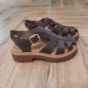 Stone Street Marron Cette sandale Fisherman associe la semelle plateforme robuste du modèle Stone Street Marron à une silhouette estivale à brides. En effet, ce modèle vous donne un look à la fois audacieux et aérien. De plus, cette sandale est confectionnée en cuir Premium Timberland® Leather, gage de robustesse. Puis, elle est dotée d’une assise plantaire OrthoLite® assurant votre confort et votre maintien. Enfin, elle est munie d’une fermeture à boucle réglable, pour être enfilée facilement, tout en préservant votre élégance. L’histoire de Timberland L’histoire des Timberland Boots remonte à la ville de Newmarket, dans le New Hampshire, aux États-Unis, où elles ont été créées en 1973. À l’origine, elles étaient destinées aux travailleurs du bâtiment et des espaces extérieurs. Les fondateurs, Nathan Swartz et sa famille, ont mis l’accent sur la qualité et la durabilité dès le départ. C’est ainsi que les premières Timberland Boots sont nées, dotées de coutures étanches, d’une semelle crantée pour une meilleure adhérence, et d’un cuir de première qualité. Cette combinaison de caractéristiques en a rapidement fait des chaussures de choix pour les travailleurs et les amateurs de plein air. Au fil des années, les Timberland Boots ont conquis un public plus large. Elles sont devenues un élément essentiel du style urbain, notamment dans le mouvement hip-hop des années 90, où elles ont été adoptées comme symbole de résilience et de style. Le nom « Timberland » lui-même évoque des images de forêts, de montagnes et d’aventures en plein air, ce qui en fait un choix idéal pour les esprits aventuriers.