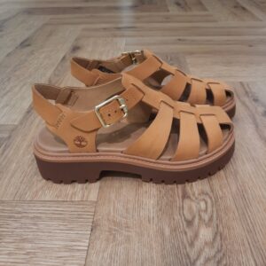 Stone Street Jaune Cette sandale Fisherman associe la semelle plateforme robuste du modèle Stone Street Jaune à une silhouette estivale à brides. En effet, ce modèle vous donne un look à la fois audacieux et aérien. De plus, cette sandale est confectionnée en cuir Premium Timberland® Leather, gage de robustesse. Puis, elle est dotée d’une assise plantaire OrthoLite® assurant votre confort et votre maintien. Enfin, elle est munie d’une fermeture à boucle réglable, pour être enfilée facilement, tout en préservant votre élégance. L’histoire de Timberland L’histoire des Timberland Boots remonte à la ville de Newmarket, dans le New Hampshire, aux États-Unis, où elles ont été créées en 1973. À l’origine, elles étaient destinées aux travailleurs du bâtiment et des espaces extérieurs. Les fondateurs, Nathan Swartz et sa famille, ont mis l’accent sur la qualité et la durabilité dès le départ. C’est ainsi que les premières Timberland Boots sont nées, dotées de coutures étanches, d’une semelle crantée pour une meilleure adhérence, et d’un cuir de première qualité. Cette combinaison de caractéristiques en a rapidement fait des chaussures de choix pour les travailleurs et les amateurs de plein air. Au fil des années, les Timberland Boots ont conquis un public plus large. Elles sont devenues un élément essentiel du style urbain, notamment dans le mouvement hip-hop des années 90, où elles ont été adoptées comme symbole de résilience et de style. Le nom « Timberland » lui-même évoque des images de forêts, de montagnes et d’aventures en plein air, ce qui en fait un choix idéal pour les esprits aventuriers.