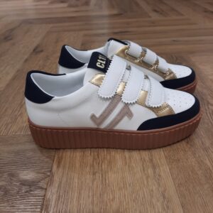 CL96 Navy Gum Conçues pour offrir un style affirmé et confortable, ces sneakers CL96 Navy Gum allient technicité et tendance estivale. D'abord, ces baskets sont confectionnées en matière synthétique lisse avec empiècements en suède bleu marine et détails dorés, elles associent élégance et robustesse. Le système triple scratch assure un ajustement parfait et rapide, tandis que la semelle crantée couleur Camel en gomme thermoplastique (TPR) garantit souplesse et adhérence. La silhouette est modernisée par un logo latéral brodé en ton sur ton et une languette contrastée signée CL11 Sneakers. Le col matelassé en tissu marine renforce le confort au porter. La marque CL11 est née dans le sud de la France, plus précisément dans le département de l’Aude, ce qui explique en partie l’origine de son nom. La marque a été créée par des passionnés de sneakers qui souhaitaient offrir des chaussures élégantes et confortables à un tarif abordable. La philosophie de CL11 repose sur trois axes : style, confort et accessibilité. La marque vise à répondre aux besoins des femmes modernes, actives et urbaines qui veulent allier tendance et praticité. Elle propose ainsi des sneakers chic et confortables, adaptées à la vie quotidienne, que ce soit pour se déplacer en ville, aller au travail ou profiter de sorties décontractées.