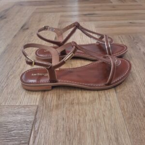 Hamatrio Tan Découvrez le modèle Hamatrio Tan, une incursion délicate au cœur de la féminité contemporaine et des escapades ensoleillées. En effet, ces sandales plates pour femme sont façonnées avec un cuir d'une qualité irréprochable. Elles se déclinent avec grâce dans une palette de couleurs élégantes. Laissez-vous séduire par la simplicité raffinée de ces sandales dont les lanières s'entremêlent harmonieusement pour épouser le pied avec finesse et confort. Leur semelle légère accompagne chaque pas avec une délicatesse aérienne, offrant une liberté de mouvement inégalée. À travers le modèle Hamatrio, c'est une célébration de la femme indépendante et solaire qui se dessine, celle qui arpente avec sérénité les rues citadines, ou qui savoure le sable chaud sous un doux éclat estival. Ces sandales incarnent un art de vivre, où l'élégance rencontre la fonctionnalité. Plongez dans l'univers des Tropéziennes, où chaque détail raconte une histoire ancrée dans l'authenticité et la passion du bel ouvrage. Les Tropeziennes par M. Belarbi : L’histoire d’un style intemporel, né à Saint-Tropez Mo Belarbi, né à Fez, est un créateur visionnaire et passionné par le cuir, l’artisanat et les voyages. En 1975 dans le village emblématique de Saint-Tropez dont il tombe amoureux, il ouvre son premier concept store «La Puce Tropezienne», un lieu unique, foisonnant de créativité et d’audace. Mo Belarbi, esprit libre et innovant y imagine des modèles qui deviendront iconiques, intergénérationnels et s’imposeront rapidement comme incontournables.