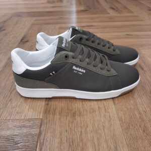 Redskins Gunran Kaki À la fois sobres et actuelles, les baskets Redskins Gunran Kaki apportent une touche dynamique au vestiaire masculin. Conçues pour un usage quotidien, elles misent sur la légèreté et le confort sans renier le style. Confectionnées en toile textile résistante, ces baskets présentent un jeu de contrastes kaki. La semelle extérieure blanche, souple et légère, assure un bon amorti tandis que la doublure intérieure textile renforce le confort au fil de la journée. Le logo Redskins est visible sur le côté externe et la languette, pour une signature discrète mais marquée. Elles se ferment par lacets plats ton sur ton, offrant un bon maintien. L'histoire de la marque Lorsque l’on parle de la célèbre marque de cuir Redskins, on pense immédiatement au look américain, au style biker avec ce petit côté rock’n roll qui souligne la tenue masculine. Or c’est bel et bien en France qu’est née la marque, créée par Serge ABOUJEDID. C’est donc en 1984 que la marque Redskins voit le jour, inspirée de la culture américaine et de la tendance rock’n roll, empreint d’une touche contemporaine dans chaque création de la marque. Cette marque résolument française est née à Gennevilliers et oriente ses collections vers la fabrication de blousons et vestes en cuir pour homme. A partir des année 90, la marque a mis au gout du jour le modèle teddy Redskins, qui n’a de cesse d’être la pièce indémodable de votre garde-robe. Aujourd’hui, stylistes et créateurs ont choisi de diversifier leur gamme pour proposer des chaussures en cuir Redskins, la maroquinerie et divers accessoires à la vente. Une stratégie payante puisque la marque devient aujourd’hui la référence du cuir de qualité. Toujours enclin à suivre le mouvement culturel et notamment cinématographique, Redskins n’hésite pas à s’associer à des personnalités influentes pour proposer ses créations au grand public. Shemar Moore, David Duchovny ou encore Johnny Hallyday ont fait partie de leur figure pour représenter leur collection.