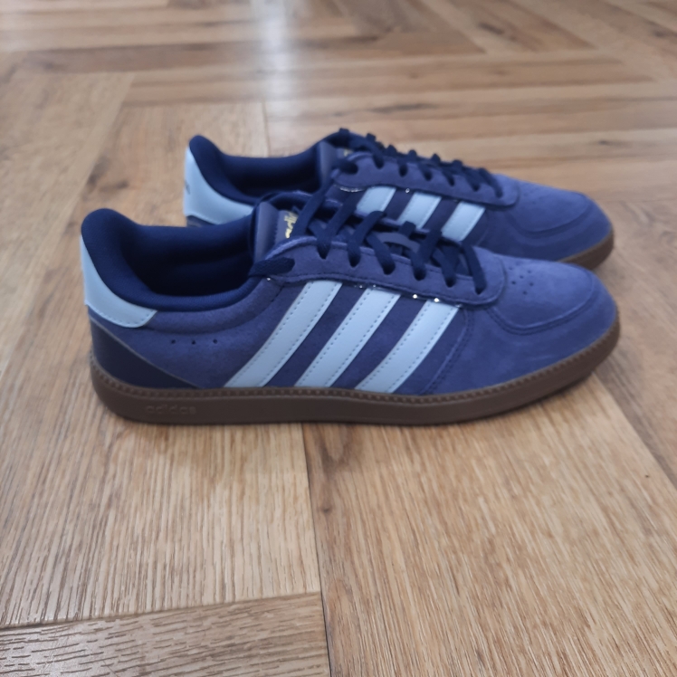 Breaknet Navy Blue Ta sneaker classique Breaknet Navy Blue passe au niveau supérieur. En effet, élégante et stylée, cette version t'accompagne de ta promenade matinale à ton dîner en ville. D'abord, ses détails perforés gardent les pieds au frais. Puis, sa tige souple, montée sur une semelle extérieure en caoutchouc classique, te suit dans tes aventures quotidiennes. Enfin, cette sneaker adidas est agrémentée des 3 bandes iconiques sur les côtés. La marque C'est le 18 août 1949 qu'Adi Dassler a démarré l'aventure adidas, avec pour objectif d'améliorer les performances des athlètes. 70 ans plus tard, adidas a laissé sa marque sur le monde du sport, mais aussi celui de la mode, de la musique, de la culture, du développement durable et bien d'autres encore. Voyage avec nous à travers le temps et découvre l'histoire d'adidas avec des modèles qui ont influencé le lifestyle d'aujourd'hui. Juste après la naissance officielle des 3 bandes en 1949, les années 50 ont connu un véritable boom technologique avec des équipements innovants pour les athlètes de classe mondiale. Ainsi, c'est pendant cette décennie qu'est apparue la Samba, toujours portée de nos jours pas les joueurs de Five et de futsal, et toujours présente dans la rue. Pendant les 50's, adidas a développé une chaussure de sprint qui a battu un record du monde et la première chaussure de football conçue avec une semelle en nylon, marquant une vraie nouveauté en termes de confort et de sensations. D'autres modèles ont vu le jour durant cette période, comme la chaussure de basketball Allround, devenue une véritable icône dans les 80's. Ces années ont été révolutionnaires, créant un véritable avant et après pour les sportifs de haut niveau. Mais ce n'était que le début de l'histoire d'adidas