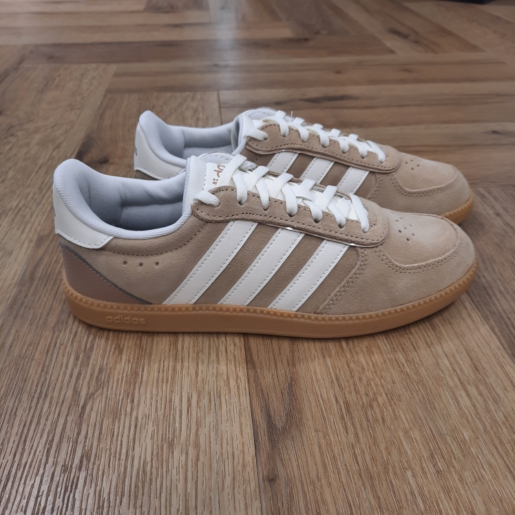 Breaknet Beige White Ta sneaker classique Breaknet Beige White passe au niveau supérieur. En effet, élégante et stylée, cette version t'accompagne de ta promenade matinale à ton dîner en ville. D'abord, ses détails perforés gardent les pieds au frais. Puis, sa tige souple, montée sur une semelle extérieure en caoutchouc classique, te suit dans tes aventures quotidiennes. Enfin, cette sneaker adidas est agrémentée des 3 bandes iconiques sur les côtés. La marque C'est le 18 août 1949 qu'Adi Dassler a démarré l'aventure adidas, avec pour objectif d'améliorer les performances des athlètes. 70 ans plus tard, adidas a laissé sa marque sur le monde du sport, mais aussi celui de la mode, de la musique, de la culture, du développement durable et bien d'autres encore. Voyage avec nous à travers le temps et découvre l'histoire d'adidas avec des modèles qui ont influencé le lifestyle d'aujourd'hui. Juste après la naissance officielle des 3 bandes en 1949, les années 50 ont connu un véritable boom technologique avec des équipements innovants pour les athlètes de classe mondiale. Ainsi, c'est pendant cette décennie qu'est apparue la Samba, toujours portée de nos jours pas les joueurs de Five et de futsal, et toujours présente dans la rue. Pendant les 50's, adidas a développé une chaussure de sprint qui a battu un record du monde et la première chaussure de football conçue avec une semelle en nylon, marquant une vraie nouveauté en termes de confort et de sensations. D'autres modèles ont vu le jour durant cette période, comme la chaussure de basketball Allround, devenue une véritable icône dans les 80's. Ces années ont été révolutionnaires, créant un véritable avant et après pour les sportifs de haut niveau. Mais ce n'était que le début de l'histoire d'adidas