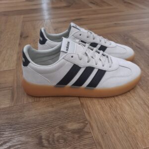 Barreda Decode Lux Mélange d’héritage et de modernité, la chaussure Barreda Decode Lux incarne la culture des gradins comme source d’inspiration pour revisiter une silhouette classique. Effectivement, ce modèle fait entrer la tradition adidas dans le style street d'aujourd'hui. Dabord, conçues pour le confort et la performance, la tige en cuir et la doublure synthétique offrent un ajustement doux et sûr. Puis, la semelle Cupsole ajoute du soutien, et la semelle extérieure en caoutchouc garantit une adhérence fiable pour les aventures quotidiennes. Les lacets sécurisent le tout. Avec le logo adidas emblématique, notamment les 3 bandes et le logo linéaire, cette chaussure complète un look qui allie un design intemporel à une attitude contemporaine. La marque C'est le 18 août 1949 qu'Adi Dassler a démarré l'aventure adidas, avec pour objectif d'améliorer les performances des athlètes. 70 ans plus tard, adidas a laissé sa marque sur le monde du sport, mais aussi celui de la mode, de la musique, de la culture, du développement durable et bien d'autres encore. Voyage avec nous à travers le temps et découvre l'histoire d'adidas avec des modèles qui ont influencé le lifestyle d'aujourd'hui. Juste après la naissance officielle des 3 bandes en 1949, les années 50 ont connu un véritable boom technologique avec des équipements innovants pour les athlètes de classe mondiale. Ainsi, c'est pendant cette décennie qu'est apparue la Samba, toujours portée de nos jours pas les joueurs de Five et de futsal, et toujours présente dans la rue. Pendant les 50's, adidas a développé une chaussure de sprint qui a battu un record du monde et la première chaussure de football conçue avec une semelle en nylon, marquant une vraie nouveauté en termes de confort et de sensations. D'autres modèles ont vu le jour durant cette période, comme la chaussure de basketball Allround, devenue une véritable icône dans les 80's. Ces années ont été révolutionnaires, créant un véritable avant et après pour les sportifs de haut niveau. Mais ce n'était que le début de l'histoire d'adidas