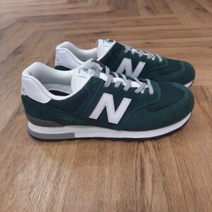 New Balance 574 Green Découvrez l’alliance parfaite entre élégance intemporelle et innovation moderne avec cette paire New Balance 574 Green. D'abord, sa couleur métallisée bronze rehaussée de détails noirs confère à votre tenue une touche sophistiquée. De plus, c'est la paire idéale pour sublimer aussi bien un look décontracté qu’urbain. La matière supérieure, composée de suède et de matériaux synthétiques, offre une durabilité remarquable et un confort optimal tout au long de la journée. La semelle intermédiaire intègre un amorti léger en EVA, garantissant une absorption des chocs efficace, tandis que la semelle extérieure en caoutchouc recyclé assure une adhérence fiable sur toutes les surfaces. Le mesh en polyester recyclé favorise la respirabilité, tout en répondant à une démarche éco-responsable. Grâce au renfort au talon, la stabilité est accrue, et la fermeture à lacets permet un ajustement personnalisé. L’emblématique logo “N” sur le côté et la languette rappellent l’héritage unique de la marque. En conclusion, ce modèle convient aux femmes à la recherche d’un équilibre parfait entre style, confort et conscience environnementale. Ces baskets deviendront vite un incontournable de votre garde-robe. La marque New balance est une marque authentique depuis en 1906. Elle produit et fabrique des chaussures dans tous les domaines sportifs. Ce qui fait de New Balance la plus grande marque de chaussures au monde. Le nom New Balance est synonyme de qualité. Il n'est donc pas étonnant que la marque ait 100 ans d'histoire. Son slogan "a more intelligent approach to building shoes" décrit très bien l'éthique de l'entreprise. Les sneakers New Balance sont résolument orientées vers la meilleure performance possible, sans pour autant négliger l'aspect esthétique. Tous les produits ont cependant en commun la même idée de base : fournir le mélange parfait de performance et de mode. C'est exactement ce que les amateurs de New Balance apprécient.